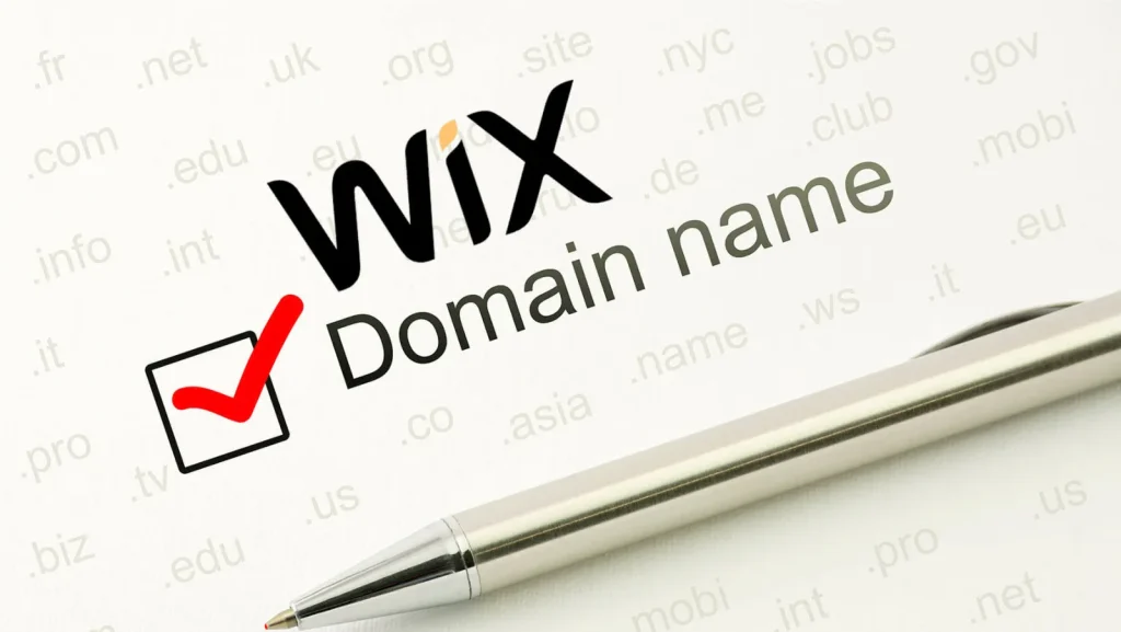 Wix logo above the words Domain name with a red tick in a checkbox, on paper printed with domain extensions and a silver pen