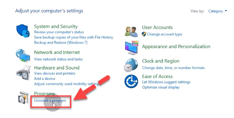 Windows Control Panel with a red arrow pointing to the Uninstall a program link under Programs