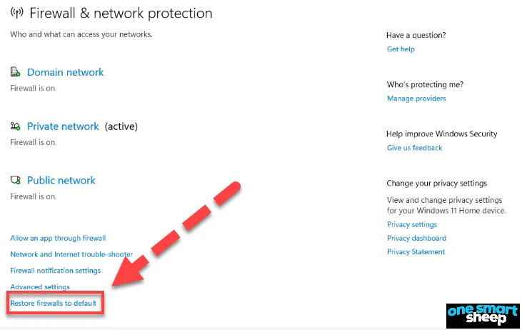Windows Firewall and network protection page with a red arrow pointing to the Restore firewalls to default link