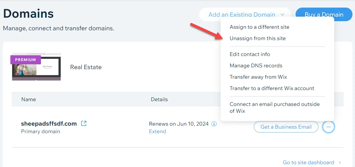 Wix Domains page with the actions menu open and a red arrow pointing to Unassign from this site, above transfer and DNS options